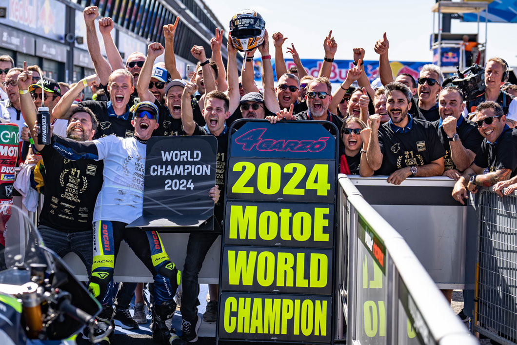 Das Bild zeigt den MotoE-Fahrer Hector Garzo zusammen mit seinem Team nach dem Gewinn der Weltmeisterschaft.